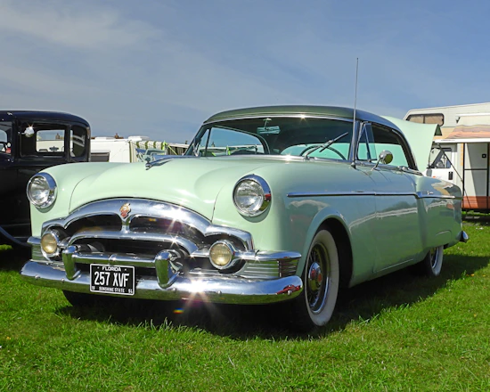 a classic car parked in a grassy field