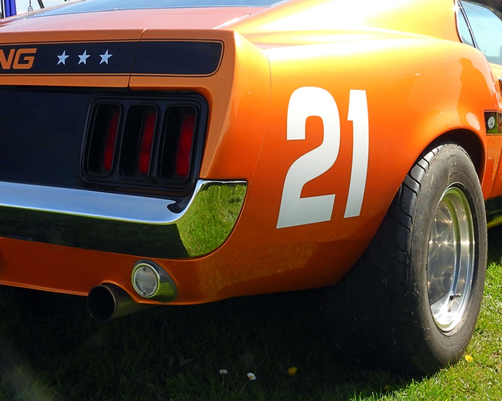 a close up of the front of an orange sports car