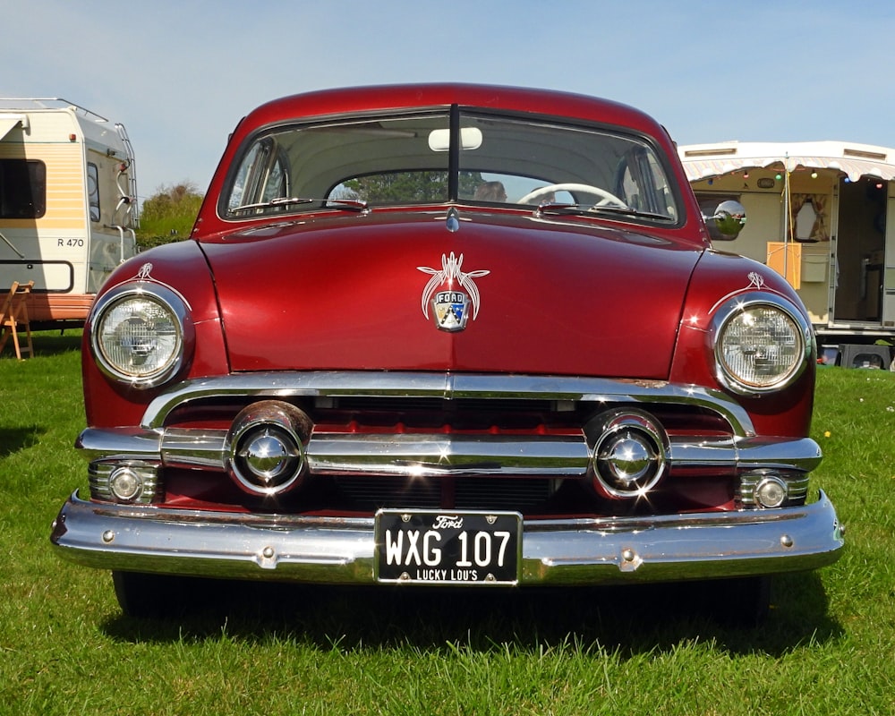 a classic car is parked in the grass