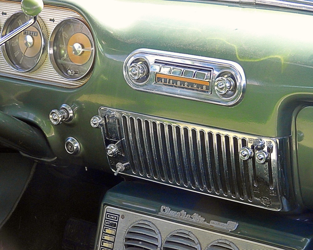 the dashboard of a green car with a radio