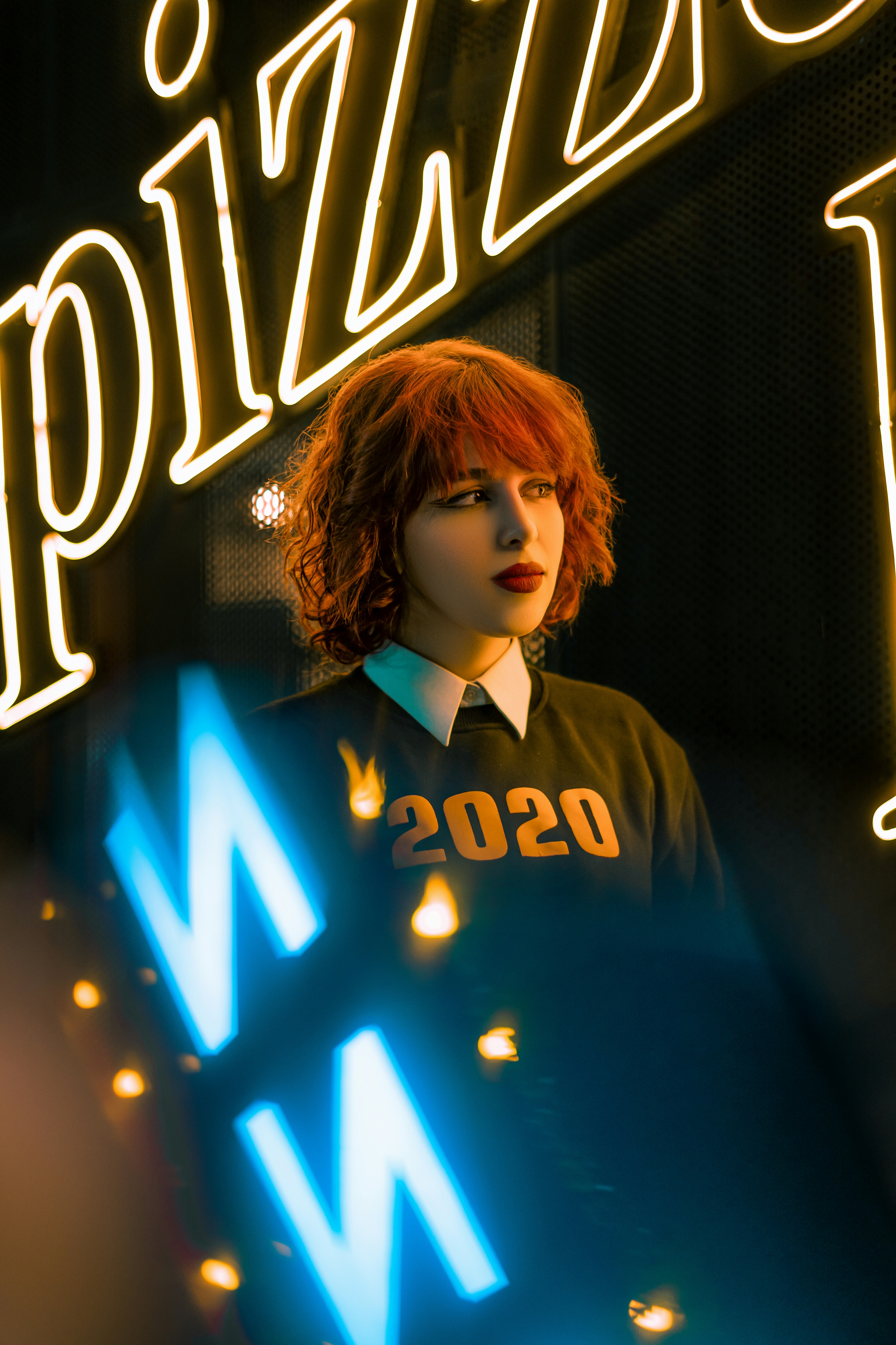 A woman standing in front of a neon sign photo – Free Iran Image on ...