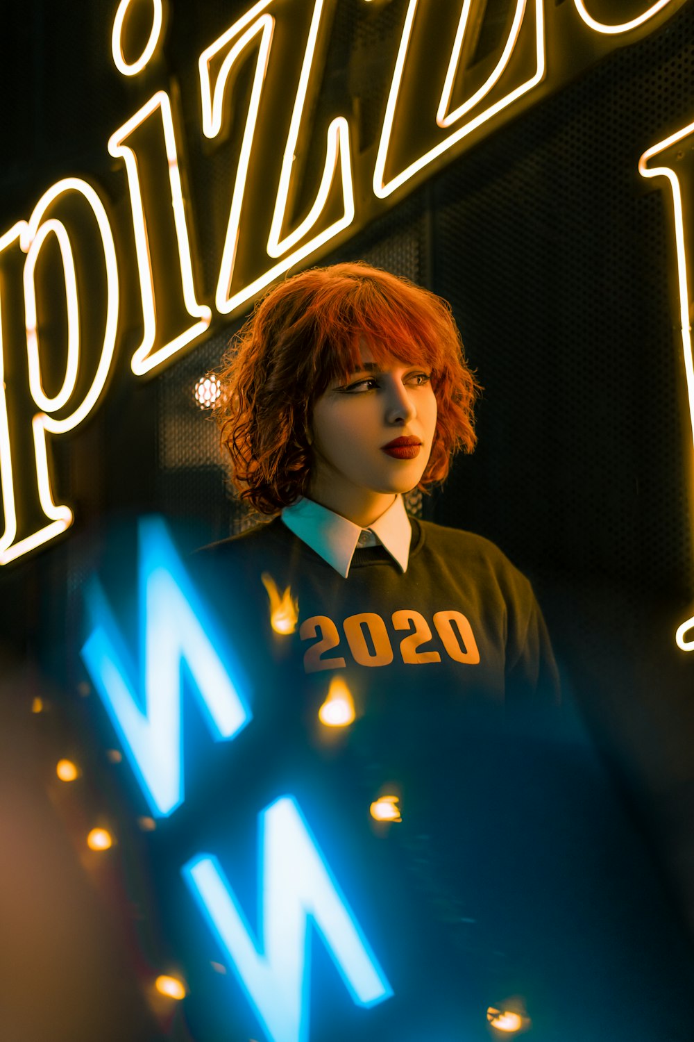 a woman standing in front of a neon sign