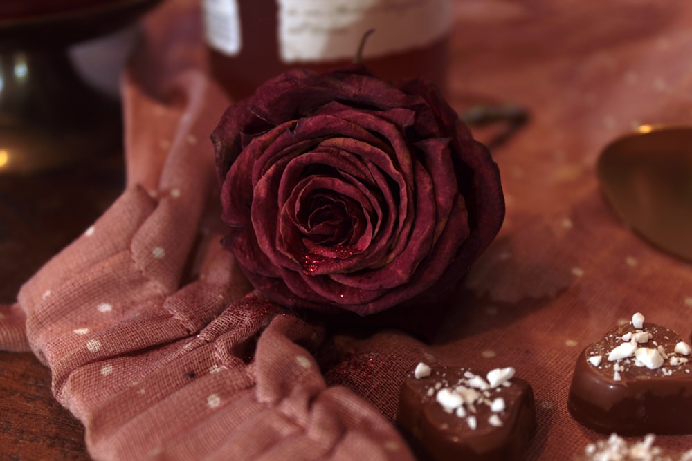 a rose sitting on top of a wooden table