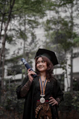 a woman in a graduation gown holding a diploma