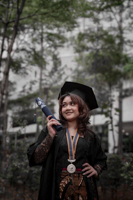 a woman in a graduation gown holding a diploma