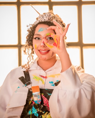 a woman wearing a crown and holding her hands up to her face