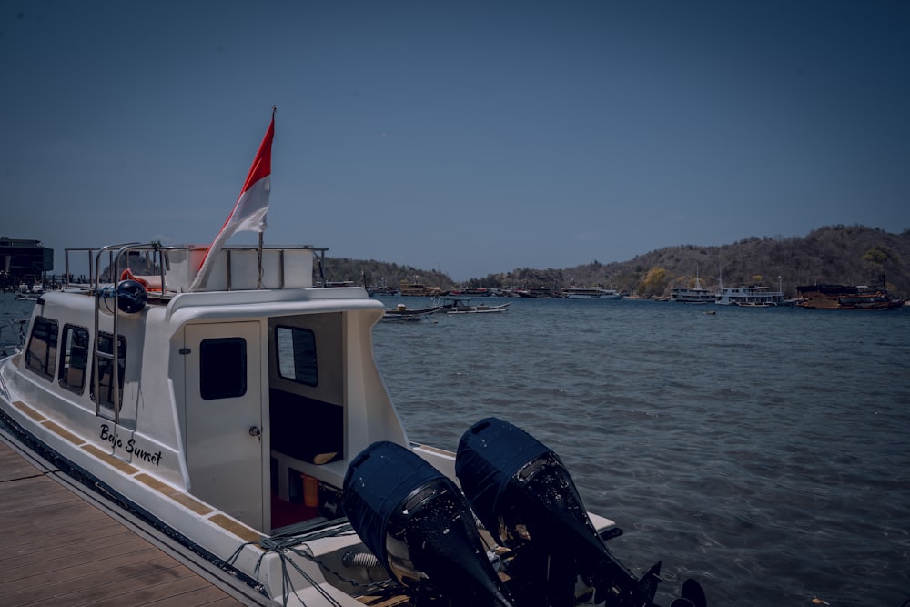 a white boat with a red and white flag on it