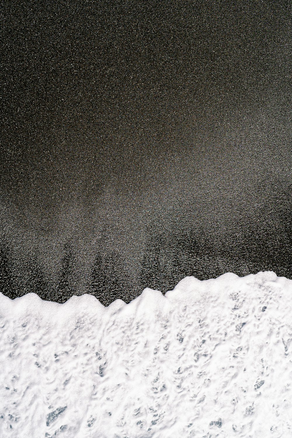 a man riding a snowboard down a snow covered slope