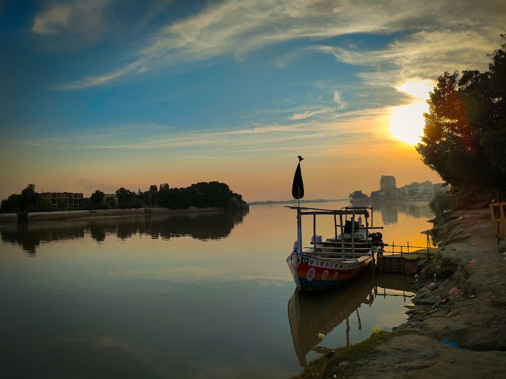 a boat is docked on the shore of a lake