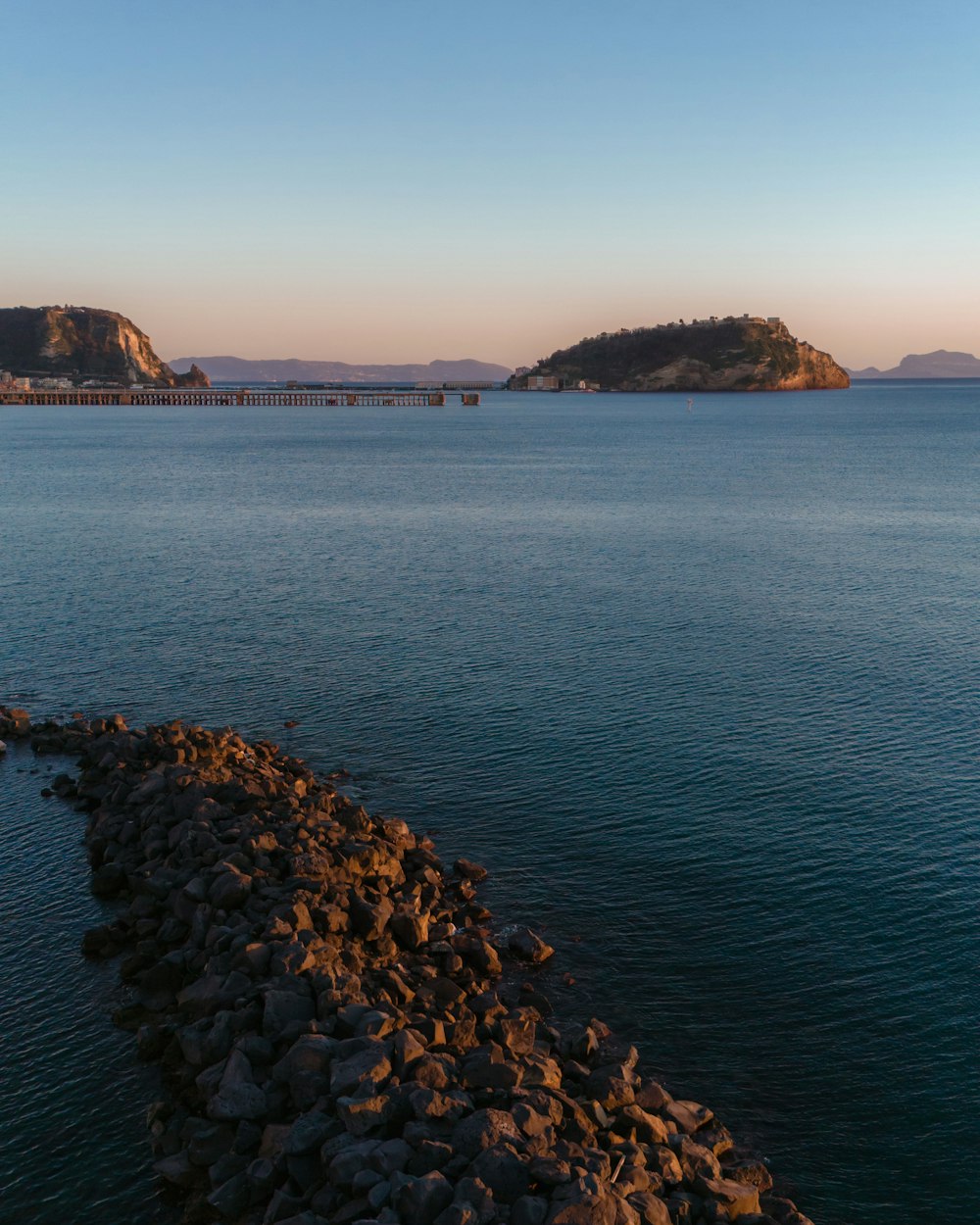 a large body of water with a bridge in the background