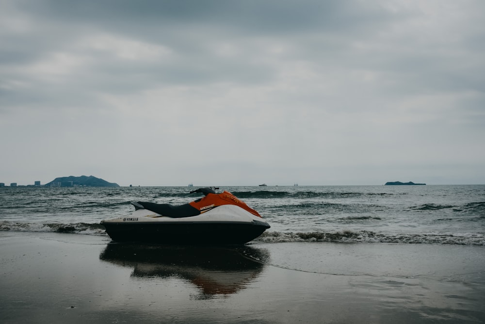 a person laying on a jet ski on the beach