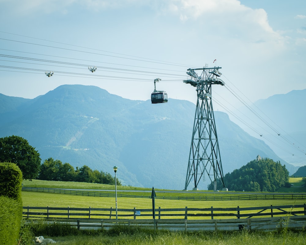 un teleférico que pasa por una exuberante ladera verde