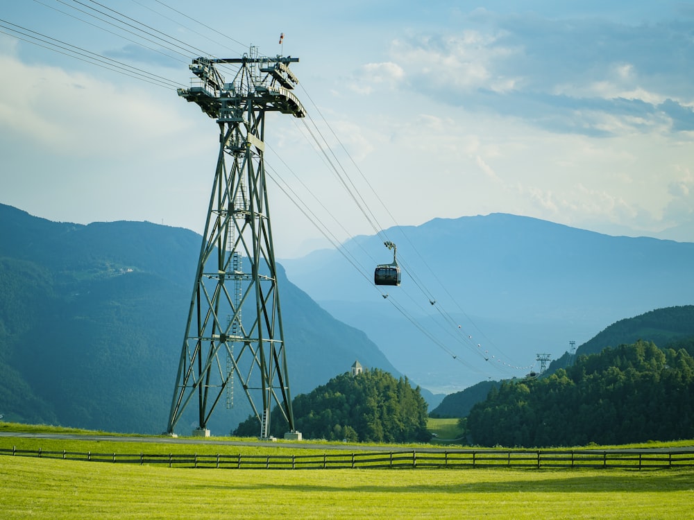 eine Seilbahn, die über einen saftig grünen Hügel fährt