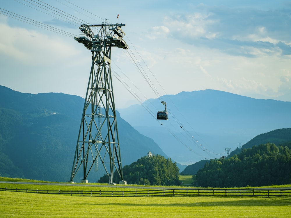 a cable car going over a lush green hillside