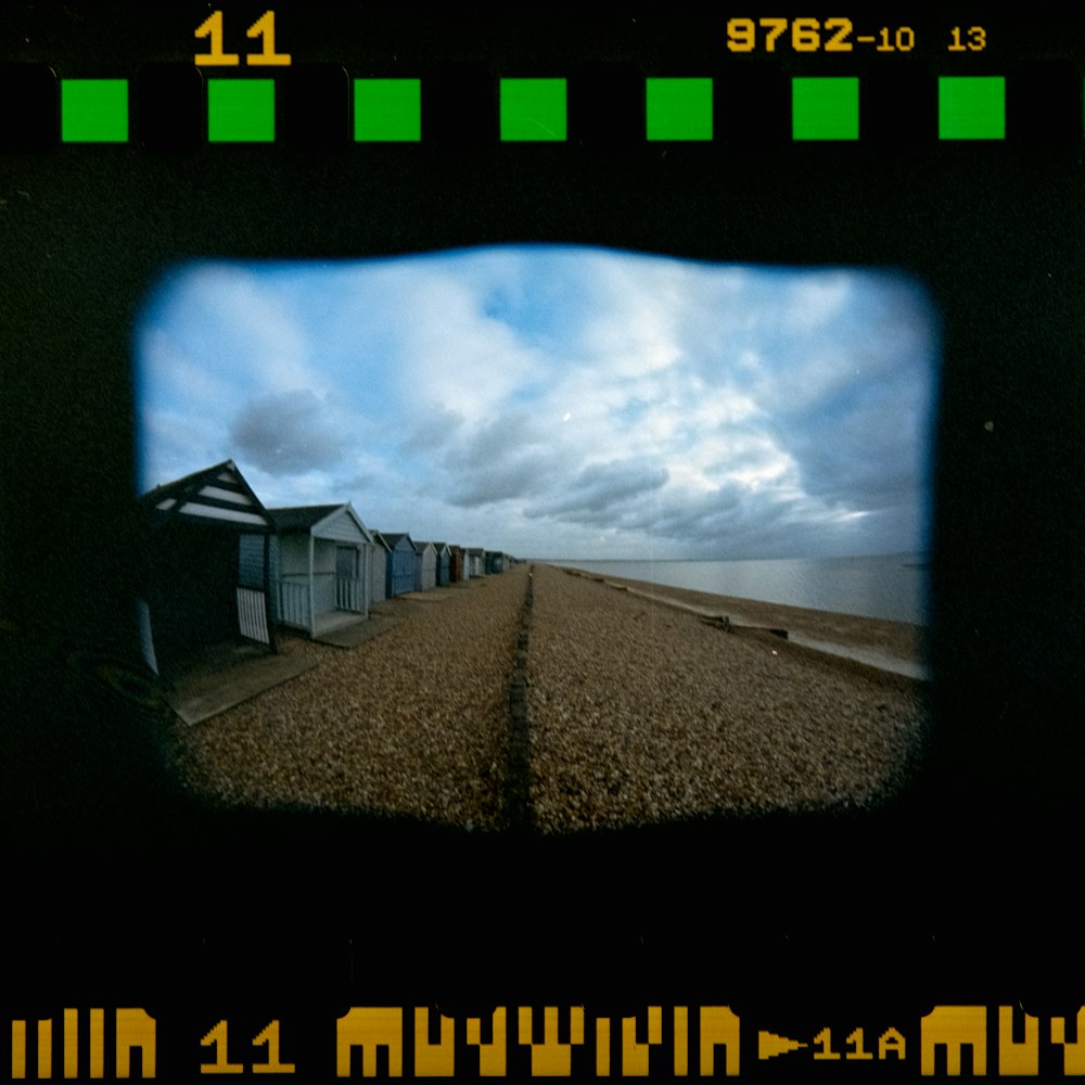 a view of a row of beach huts through a hole in a wall