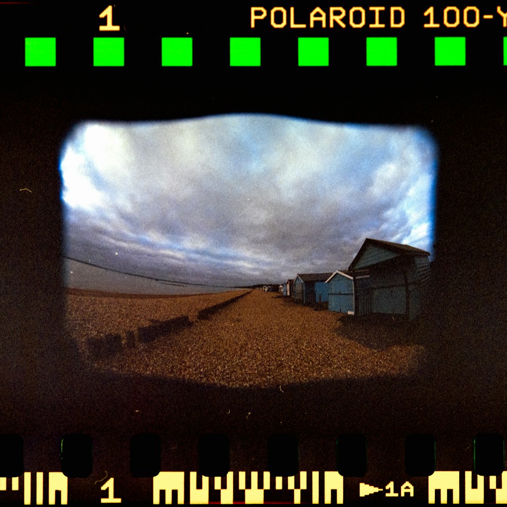 a polaroid view of a farm with a house in the background