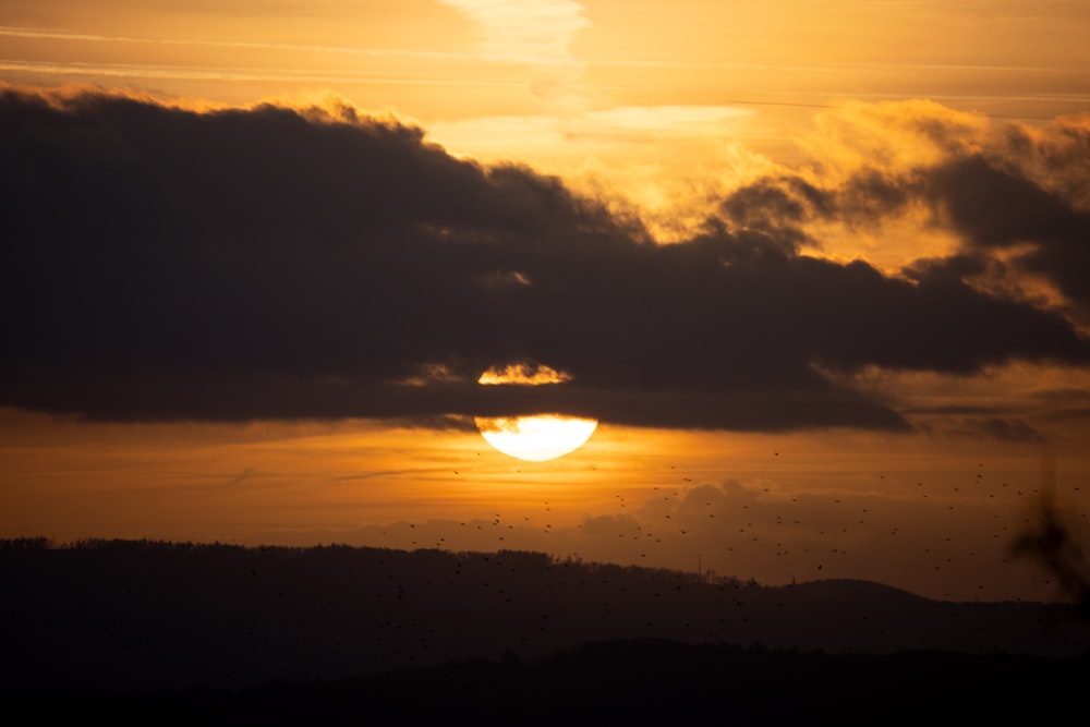 the sun is setting over a mountain range