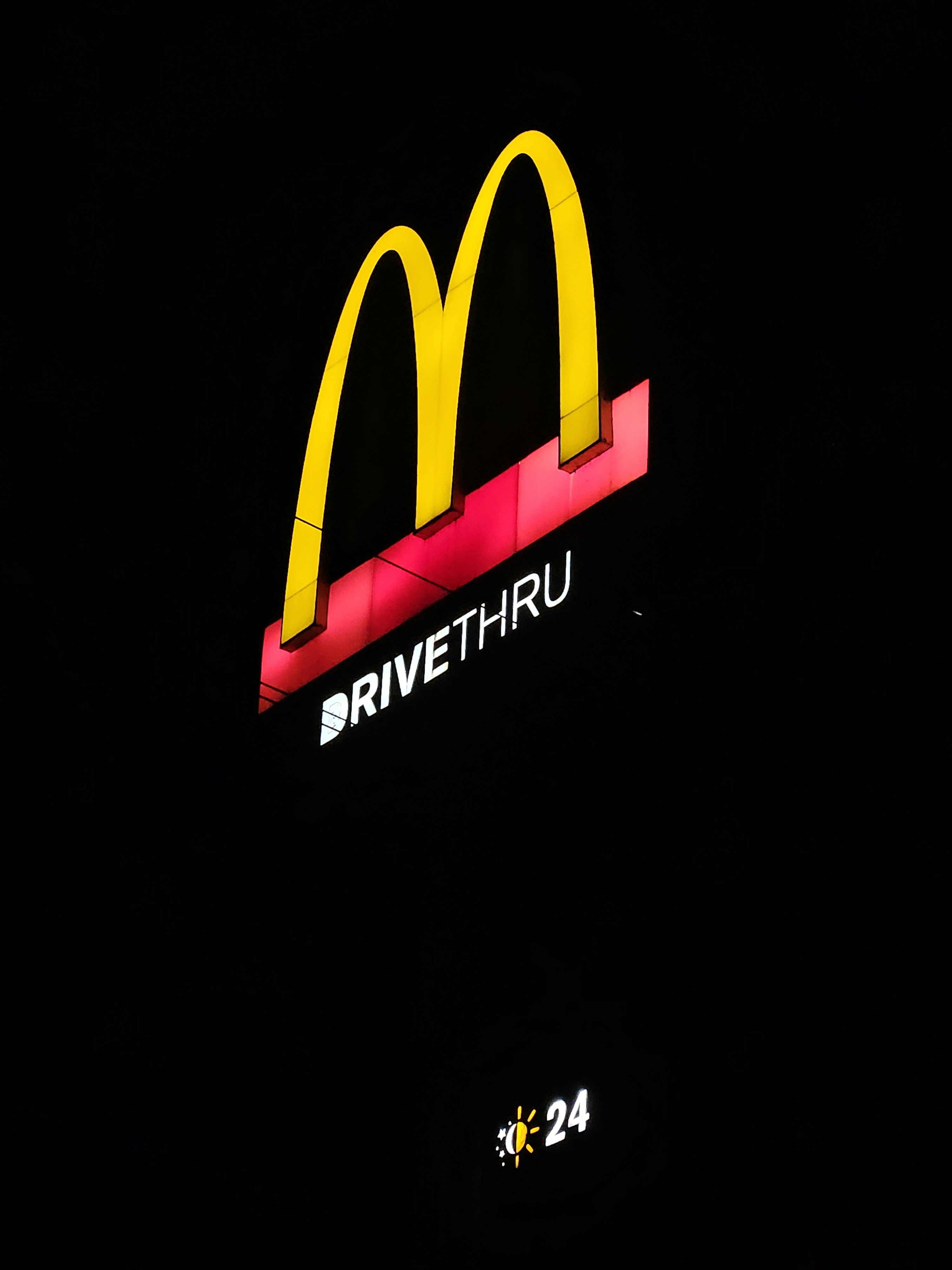 a mcdonald's sign is lit up at night