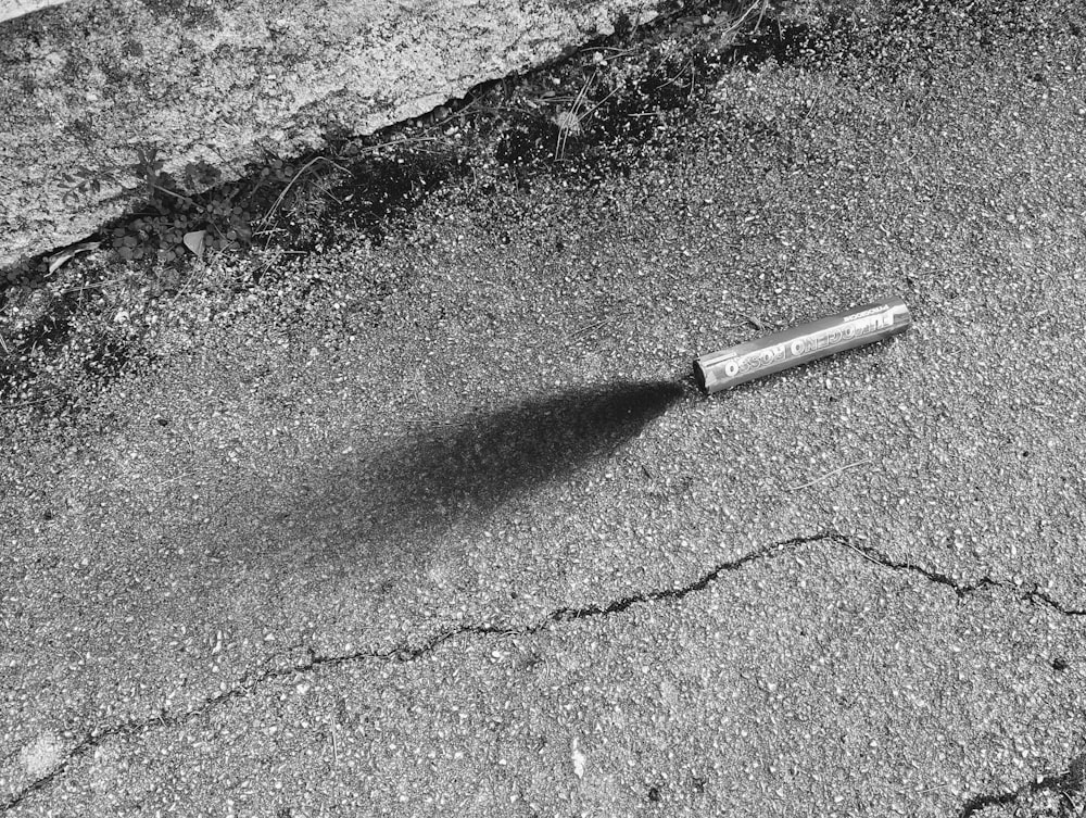 Una foto en blanco y negro de un cigarrillo en el suelo