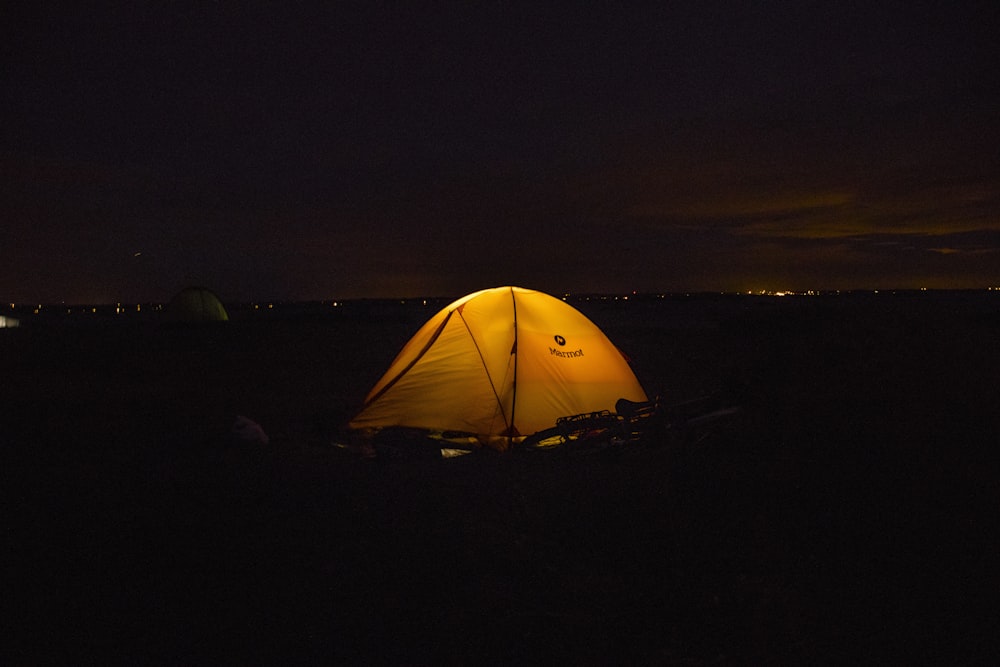 a tent is lit up in the dark