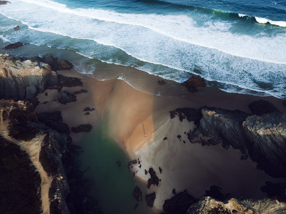 an aerial view of a beach with waves coming in