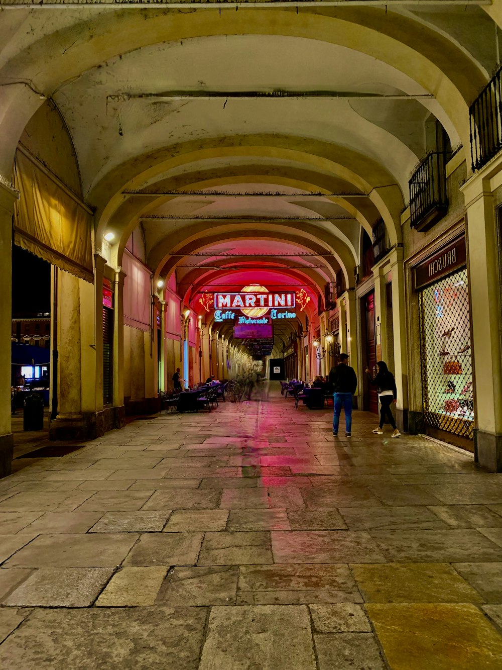 un uomo che cammina lungo una strada accanto a edifici alti