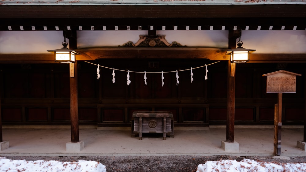 a building with a bench and lights in the snow