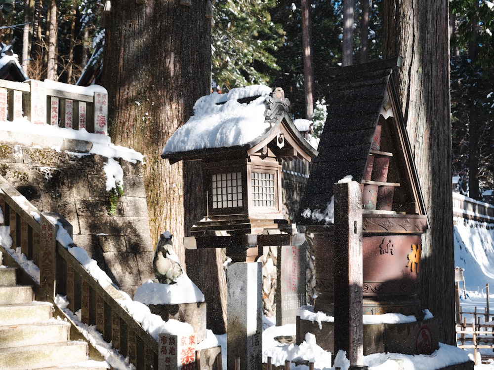 a bird house in the middle of a snowy forest