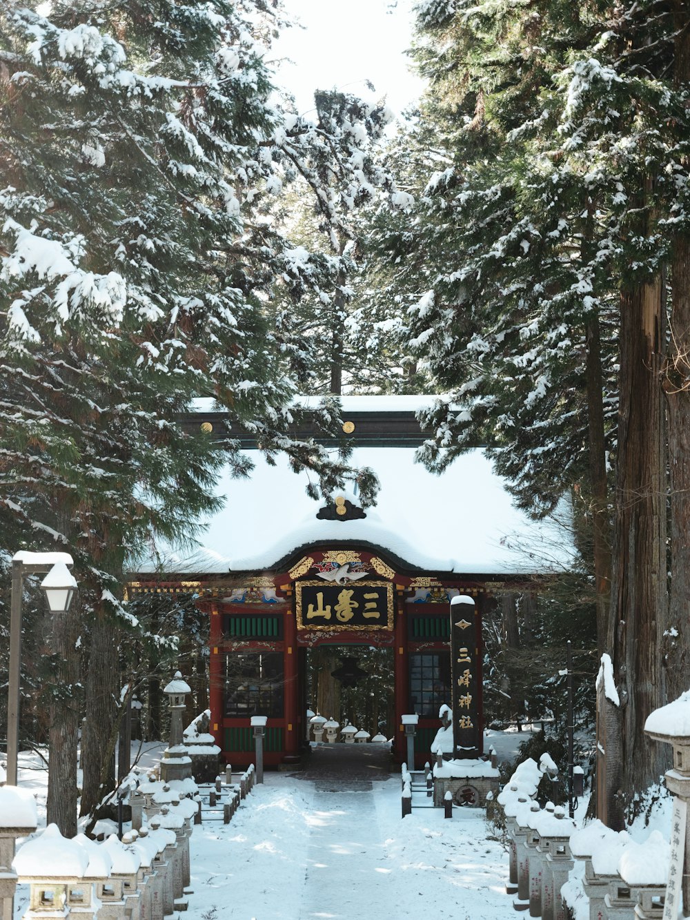 a small shrine in the middle of a snowy forest