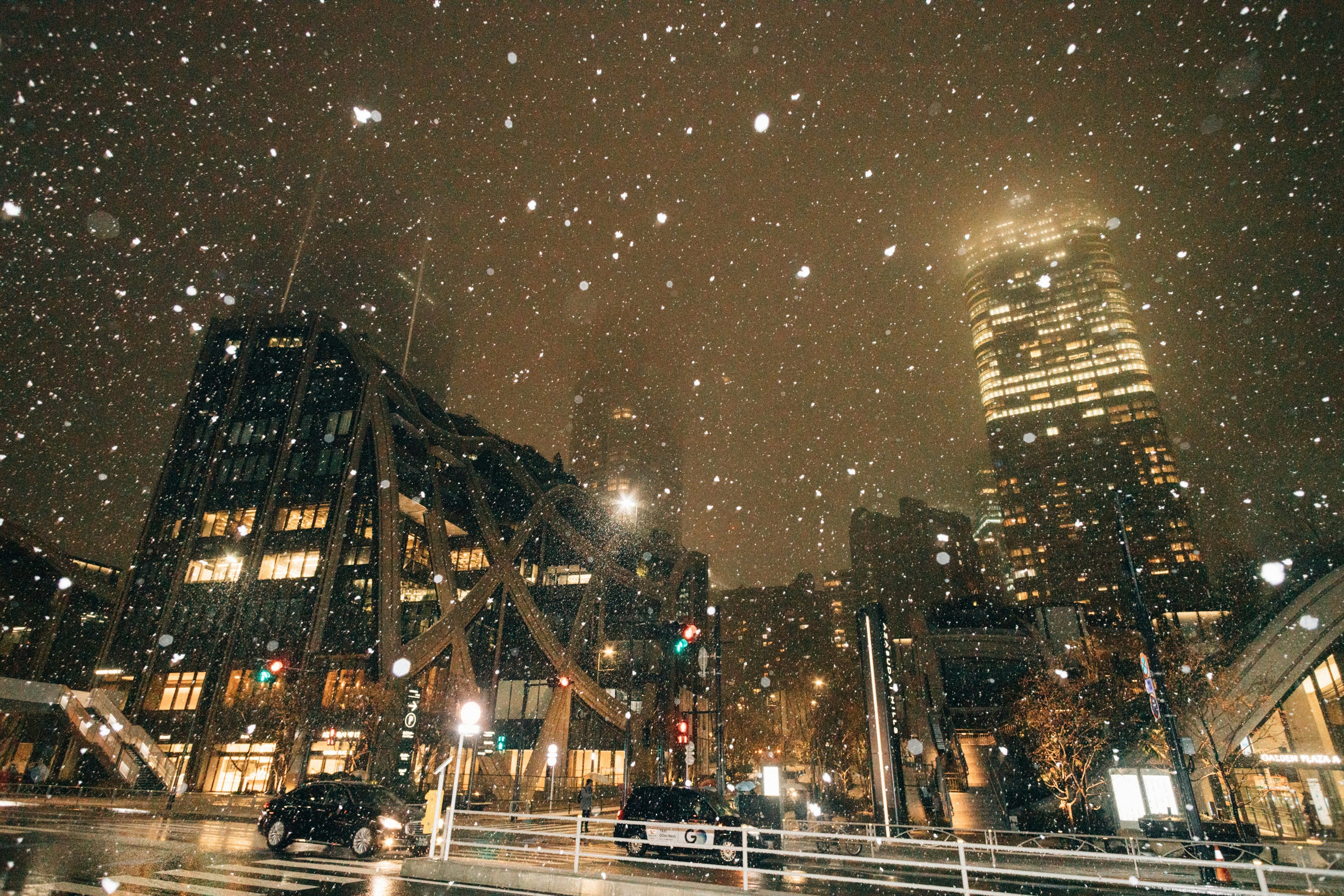 a city street at night with snow falling