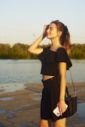 a woman standing next to a body of water