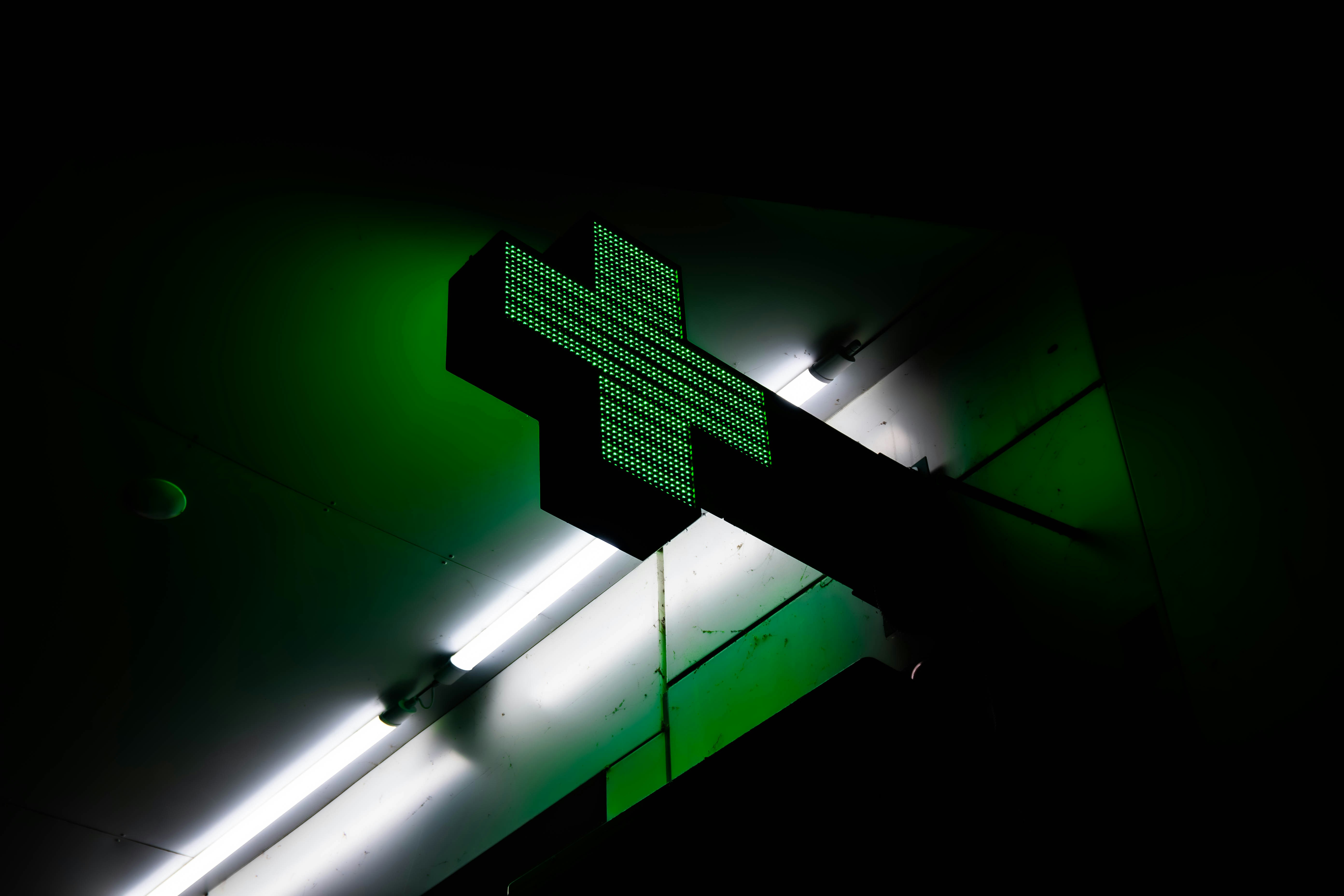a cross on the side of a building lit up at night