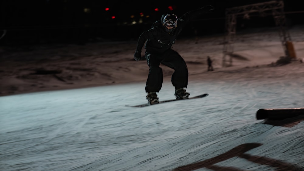 a man riding a snowboard down a snow covered slope