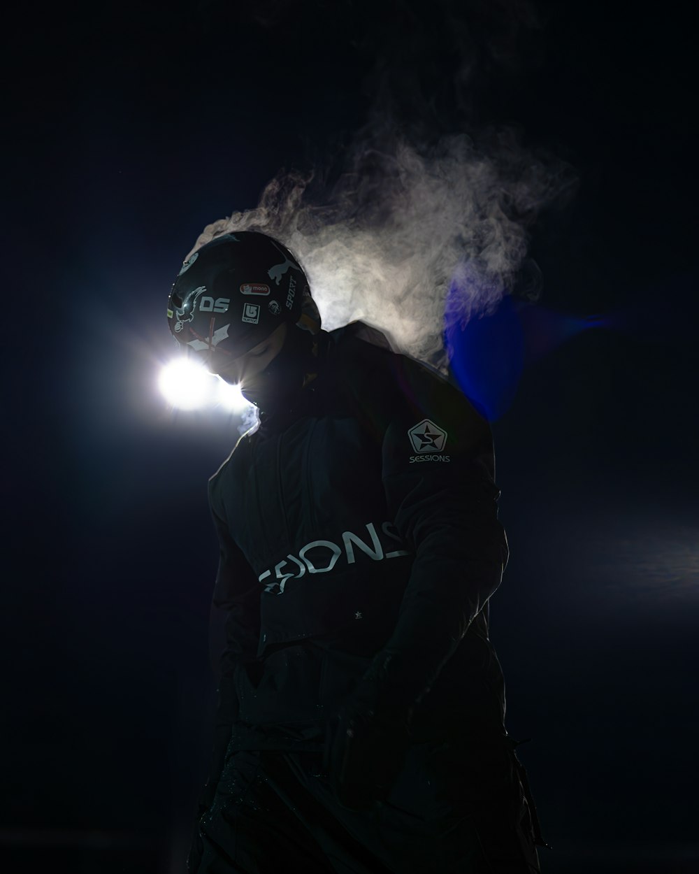 a man standing in the dark wearing a helmet