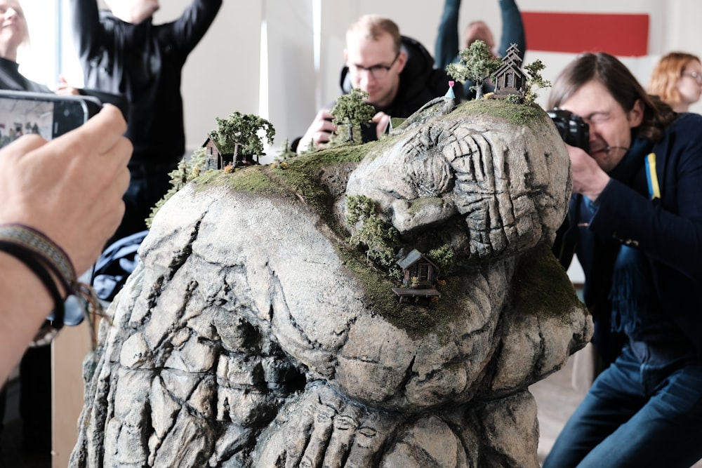 a group of people taking pictures of a sculpture