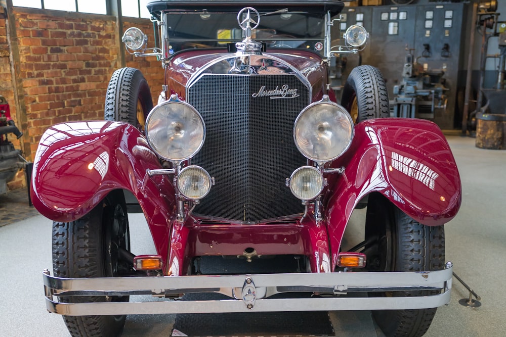 a vintage red car is parked in a garage