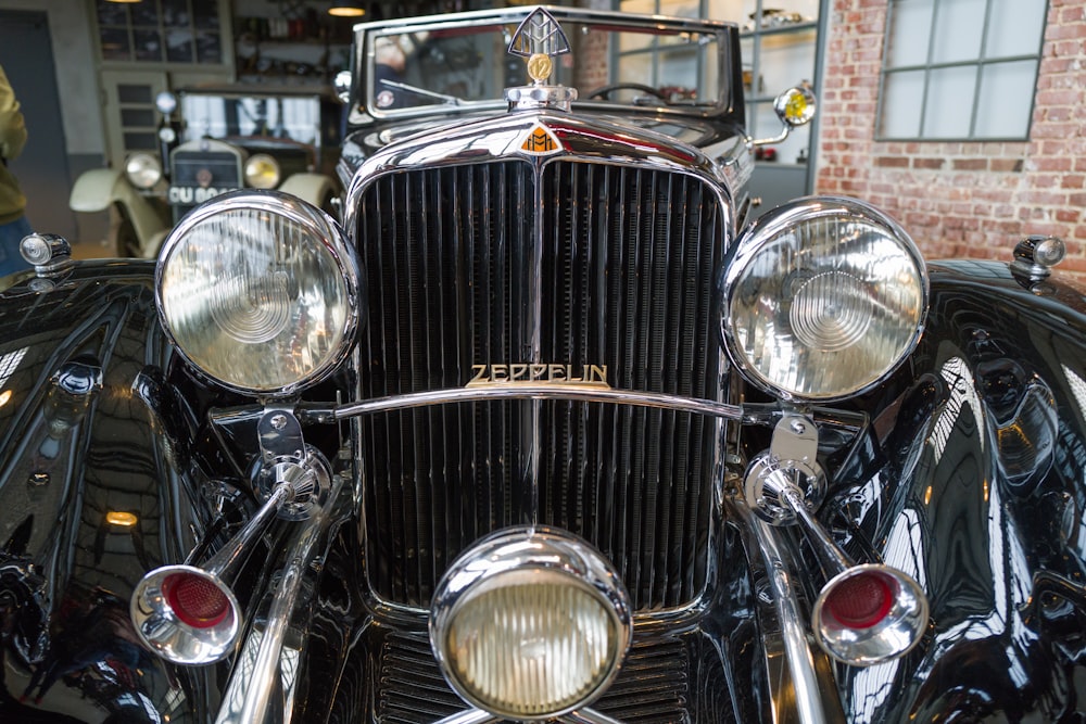the front end of a vintage car in a garage