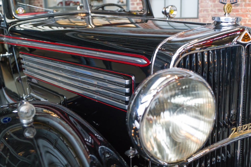 an old fashioned black car parked in a garage