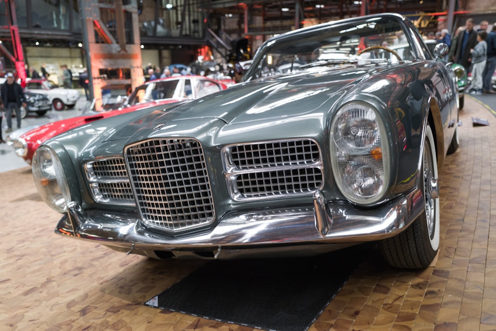 a silver car parked on top of a hard wood floor