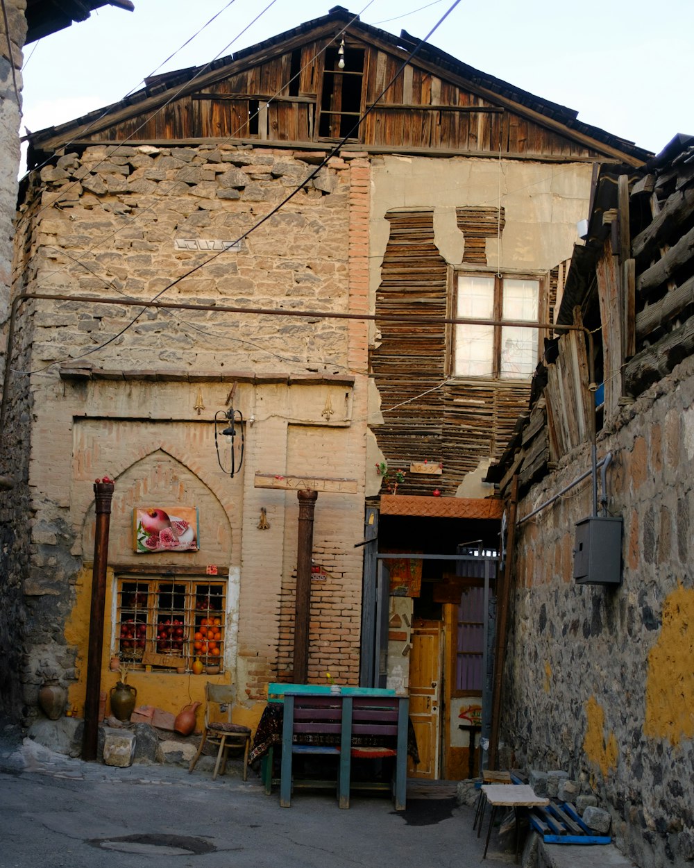 an alleyway with tables and chairs in front of a building