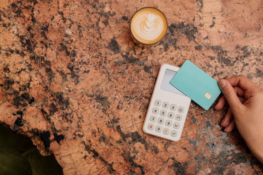 a calculator and a cup of coffee on a table