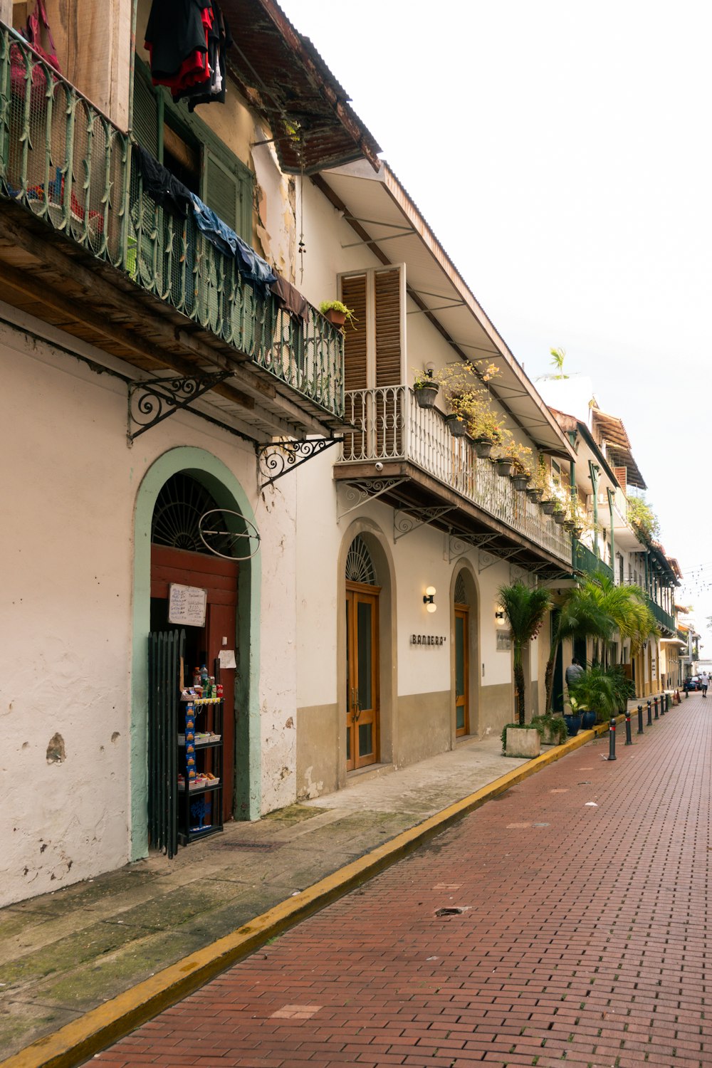 a brick sidewalk with a building with balconies and balconies