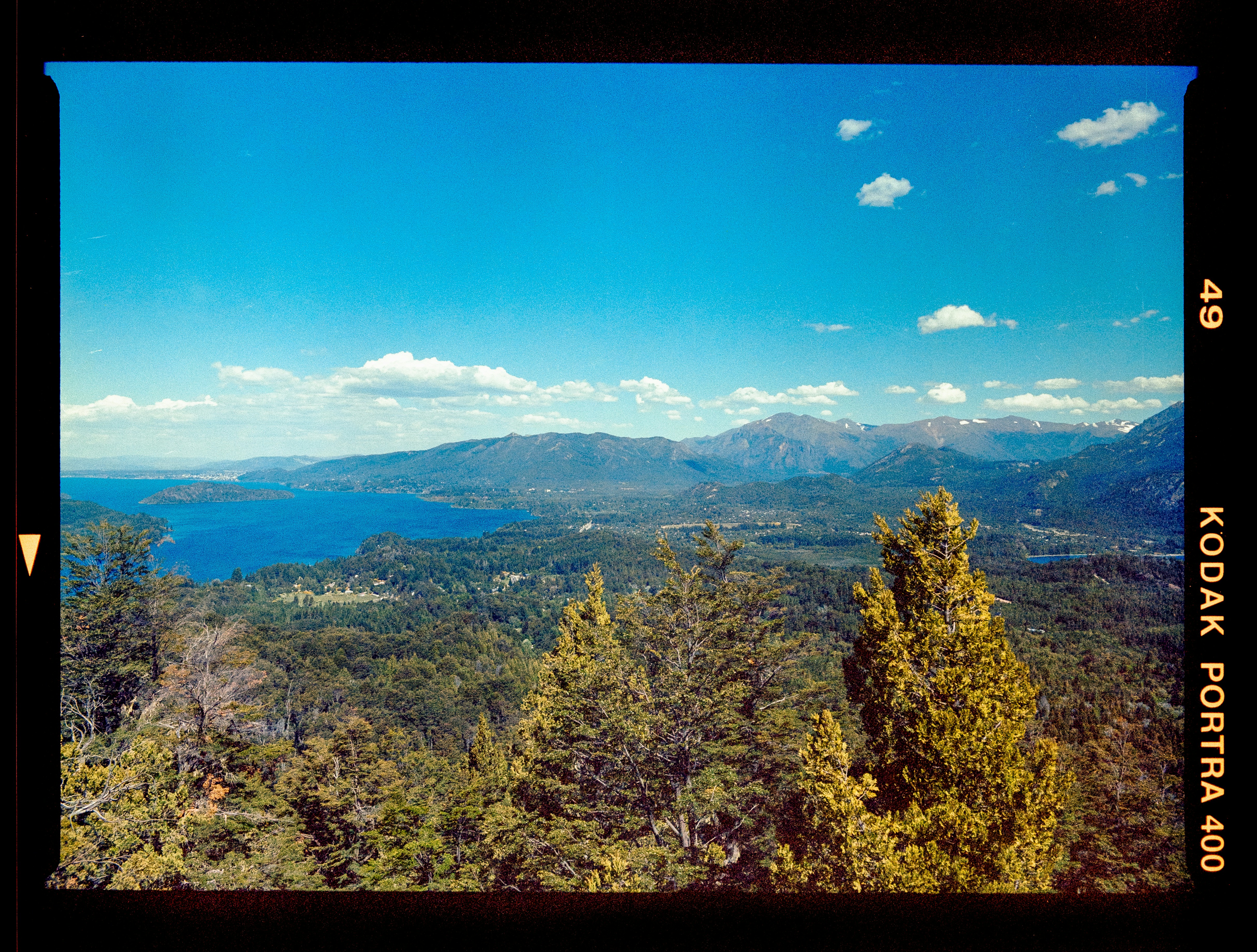 a scenic view of a mountain range with a lake in the distance