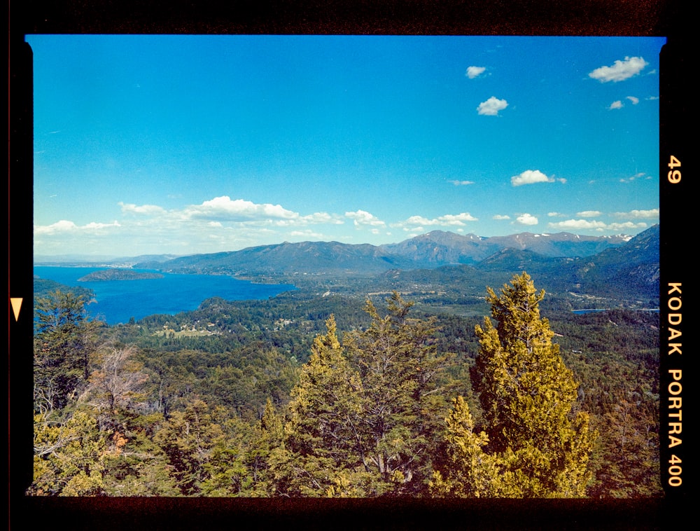 a scenic view of a mountain range with a lake in the distance