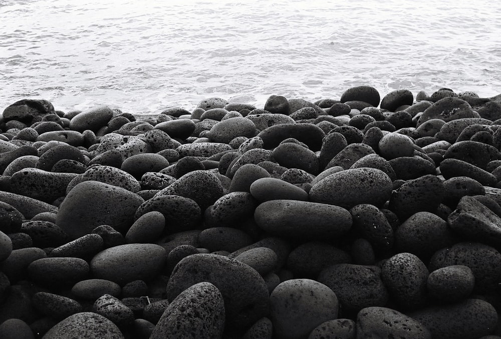 a black and white photo of rocks and water