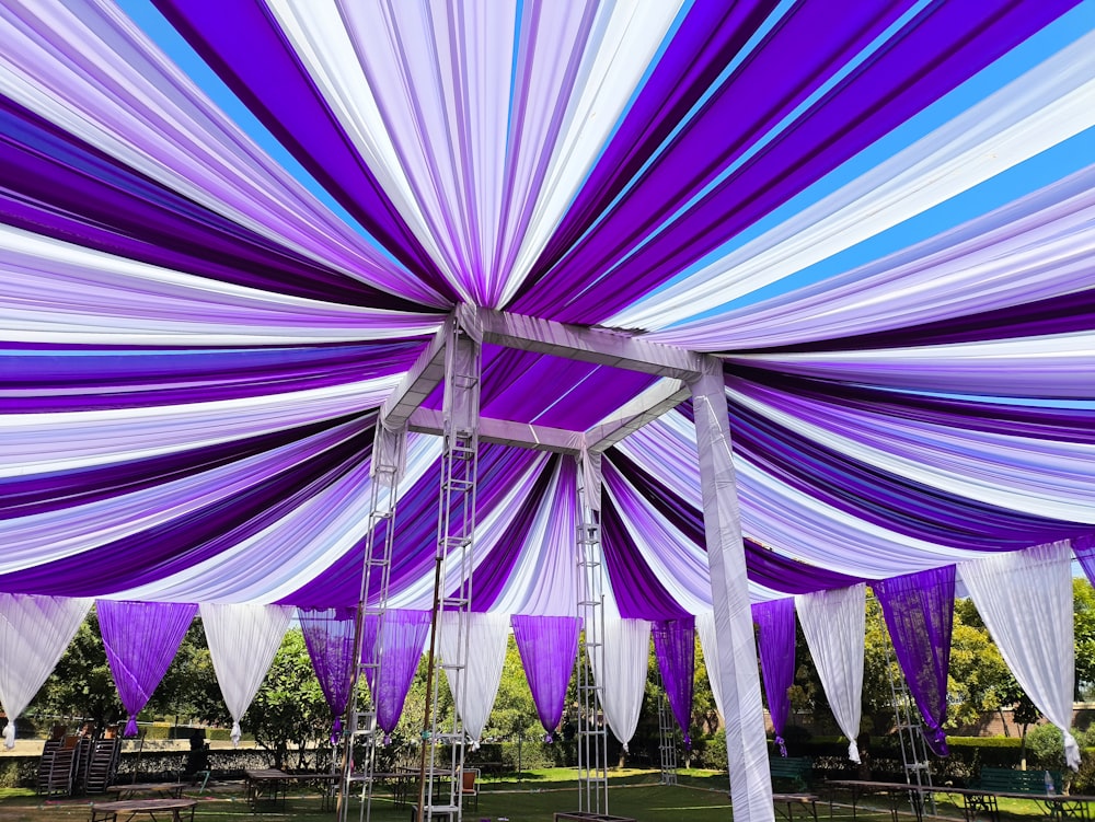 a purple and white canopy with white and blue draping