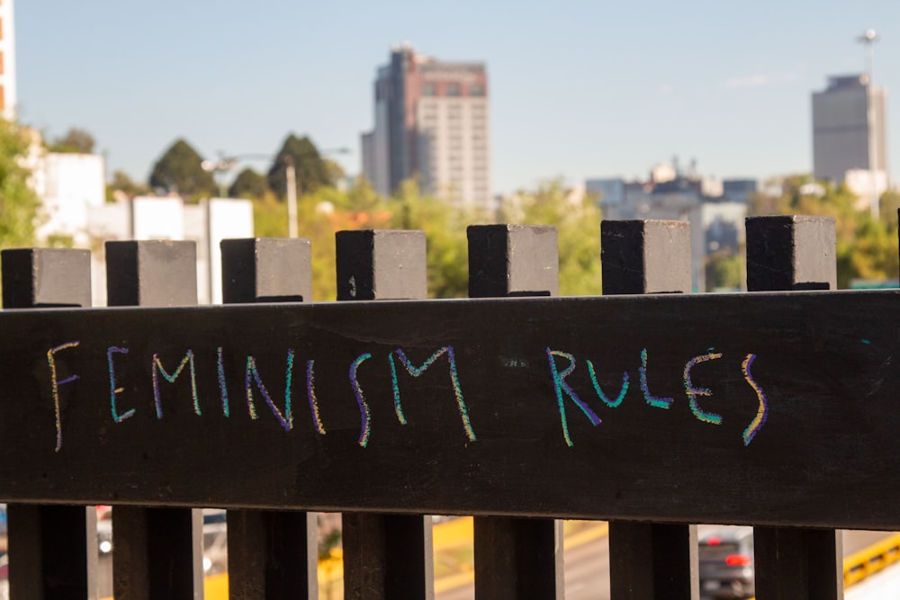 a wooden fence with graffiti written on it