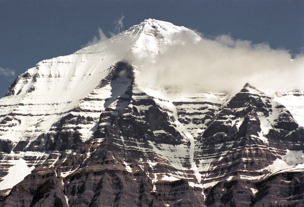 a large mountain covered in snow under a blue sky