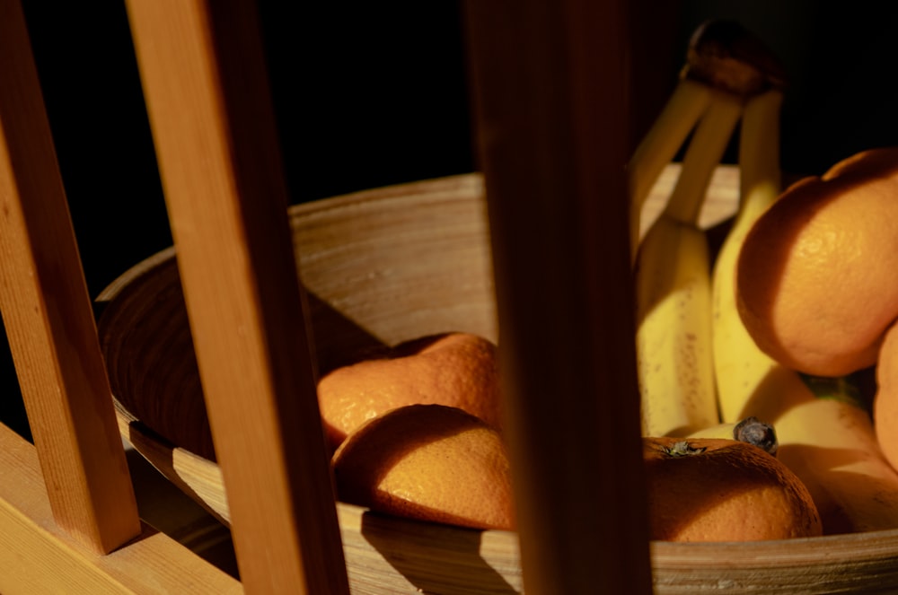 a bowl of oranges and bananas on a table