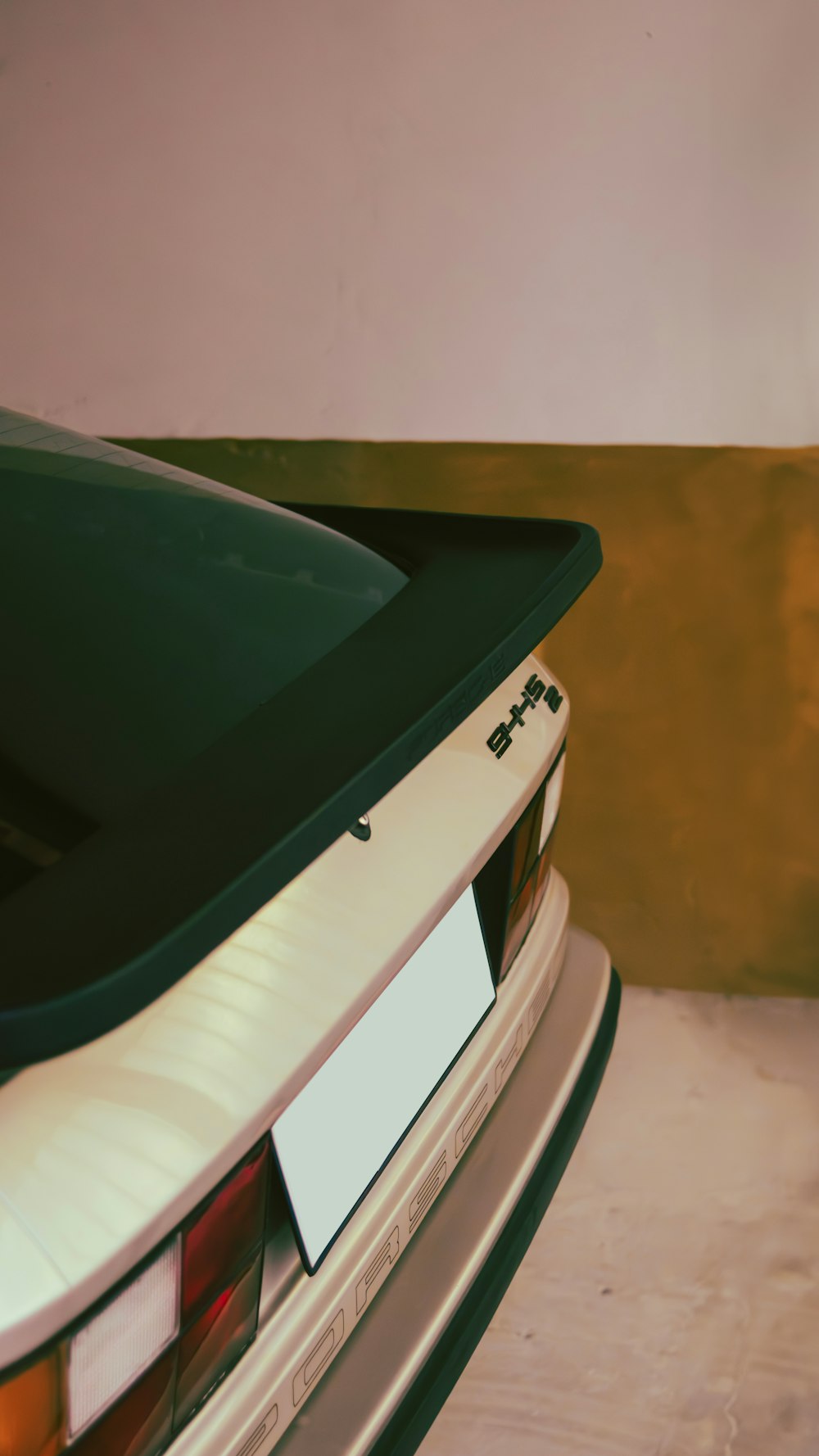 a white car parked next to a wall